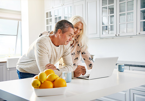 Retired Couple On Laptop Computer Withdrawing From 401k