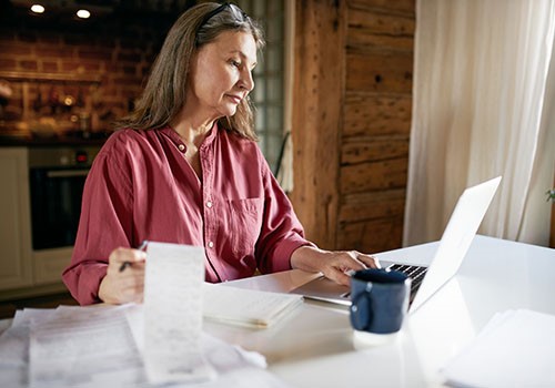 A woman at her computer calculating her Medicare Part N costs.