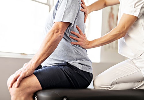 A man receives chiropractic treatment on his back.